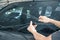 Man is changing windscreen wipers on a car