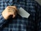 a man in a checked blue shirt tucks a business card into his pocket