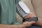 Man checking blood pressure with modern monitor and smartphone indoors, closeup