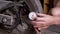 A Man Checks the Air Pressure in a Motorcycle Tire with a Pressure Gauge