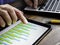 Man checks a business graph on a tablet. Modern paperless office work.