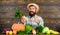 Man cheerful bearded farmer hold horseradish wooden background. Farmer straw hat presenting fresh vegetables. Farmer