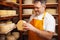 man cheesemaker in the cellar, beautiful wooden shelves with a