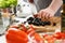 Man chef cutting olives on wooden cutting board, add ripe vegetable to salad