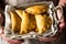 Man chef holding in hands a wicker basket with freshly baked vegetarian empanadas turnover pies with vegetables kinfolk