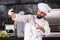 Man chef use mobile at restaurant kitchen. Bearded cook with knife make selfie.