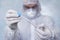 A man in a chemical protection suit holds a test tube for analysis. COVID-19. Coronavirus swab sample COVID-19. swab coronavirus