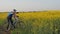 A man with a child on a bicycle. Dad and daughter in nature. Dad explains to the child. Sport family.