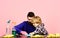 Man and child cleaning brown wooden table with sponges.