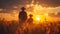 A man and child enjoy a serene walk through a vast field under a vibrant sunset