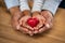 Man and child hand holding red heart stone