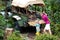 Man and child push car stuck in mud in jungle. Family pushing off road vehicle stuck in muddy dirt terrain in tropical forest.