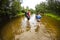 A man with a children crosses the river ford.