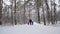 Man and children hold hands and run in the winter forest. Slow motion