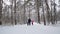 Man and children hold hands and run in the winter forest. Slow motion