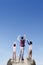 Man and children raise hands at mountain peak