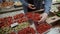 Man chooses currant and strawberries at open farmer market