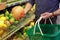 Man chooses a pomelo or Thai grapefruit at the grocery store. Hand with fruit close-up.