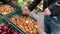 Man choosing onion in store. Close up of man`s hand looking for good vegetables on store counter.