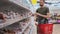 Man is choosing sausage in supermarket, reading ingredients