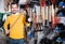 Man choosing various tools in garden equipment shop