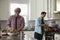 Man chopping while his boyfriend cooks ingredients in a pan