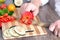 Man chopping paprika on cutting board with knife in kitchen