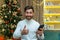 a man on Christmas looks at the camera and shows a finger up affirmatively holds a smartphone in his hands, sits at