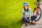 Man and city rolling bicycle, environmentally friendly transport. Beautiful young caucasian woman worker sitting resting on the gr