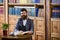 Man in classic suit sits in vintage interior, library,