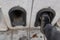 Man clean his shoes on boot scraper in a low wall at the entrance to the drive of a terraced house. Metal arch shaped with face