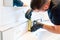 Man cleaning a bathroom sink with a scraper blade and micro fiber cloth to remove lime and stains