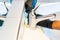 Man cleaning a bathroom sink with a scraper blade and micro fiber cloth to remove lime and stains