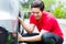 Man cleaning car rims with sponge