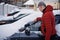 Man cleaning car from snow and ice with brush and scraper tool during snowfall. Winter emergency. Weather-related