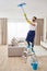 Man cleaning ceiling and lamps in living room. House cleaning service concept.