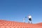 Man cleaning chimney on tiled roof