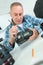 Man cleaning digital camera body using brush