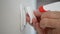 Man Cleaning and Disinfecting Light Switch with Disinfectant and a Clean Wipes