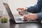 Man cleaning laptop keyboard with sanitizer, close up