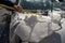 man cleaning snow off his car using ice scrapper after winter snowfall.