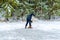 A man cleaning snow with a shovel. Clearing a skating or ice rink in the forest. Winter, fun, work, shoveling snow