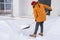 Man cleaning snow from sidewalk and using snow shovel. Winter season