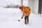 Man cleaning snow from sidewalk and using snow shovel. Winter season