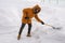 Man cleaning snow from sidewalk and using snow shovel. Winter season