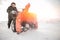 Man cleaning snow from sidewalks with snowblower machine winter