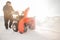 Man cleaning snow from thrower blower machine removal ice storm winter