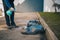 Man cleaning the underside of a robotic autonomous lawnmower with the help of a cleaning solvent as part of a service plan. Gunk