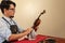 Man cleaning a violin in a musical instrument repair workshop