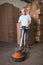 Man cleaning warehouse floor with machine